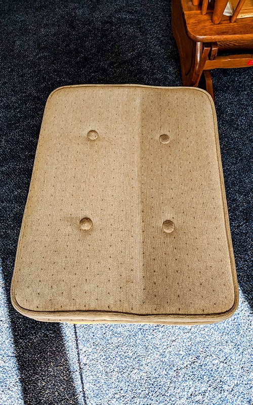 Upholstered cushion that has been half cleaned by Steamway carpet cleaning